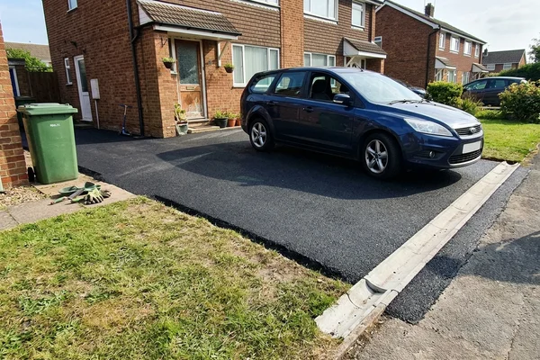 The same driveway after resurfacing, with tidy edges and clear falls