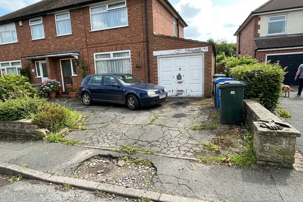 Cracked and potholed tarmac driveway before repair