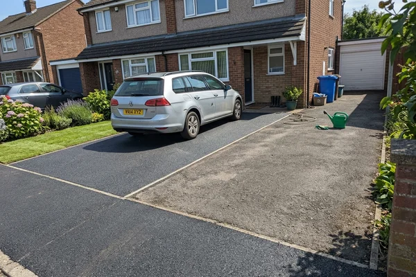 Driveway extension where new surfacing meets the original drive at a clean cut joint