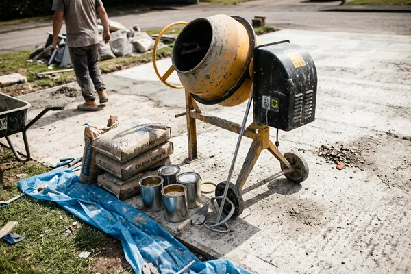 Forced action mixer on site with bags of aggregate and resin ready for the next batch
