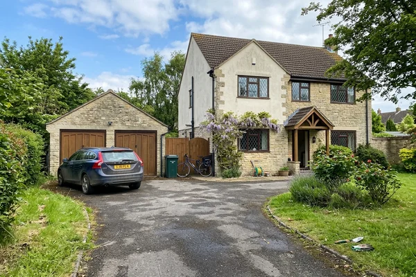 Long tarmac driveway sweeping up to a detached Gloucestershire house