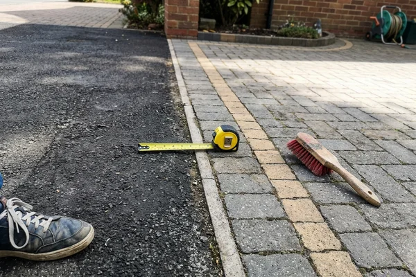 Junction where new tarmac meets a block paved entrance apron and border course