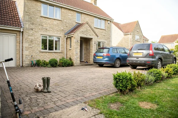 Wide block paved driveway with brick edging in front of a detached Cheltenham house
